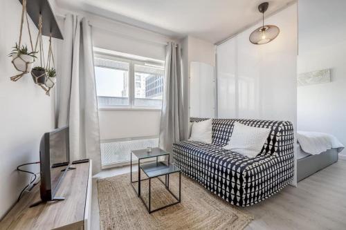 un salon avec un canapé et une télévision dans l'établissement Studio Vatel Nantes, à Nantes