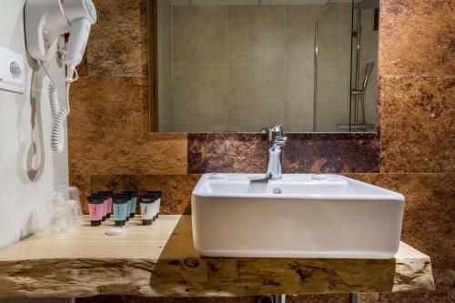 La salle de bains est pourvue d'un lavabo blanc et d'un téléphone. dans l'établissement Hotel Sant Gothard, à Arinsal