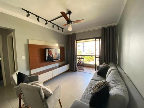 uma sala de estar com um sofá e uma televisão em Apartamento na Praia da Enseada - Guarujá SP no Guarujá