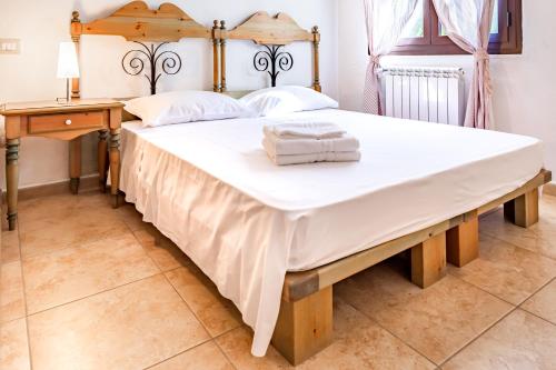 a large bed in a bedroom with a wooden bed frame at Villa Pinewood in Santa Margherita di Pula