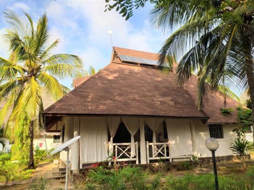 a small white house with a palm tree at Mambrui Villa 34, Villa 36 in Malindi