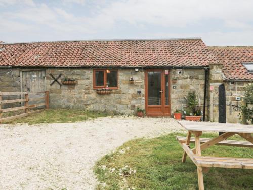 a stone cottage with a picnic table in front of it at Forest View Cottage in Scarborough