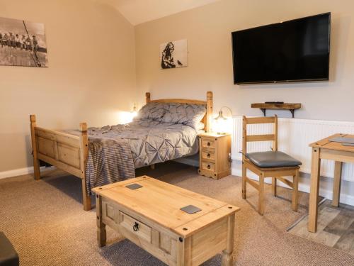 a bedroom with a bed and a flat screen tv at Forest View Cottage in Scarborough