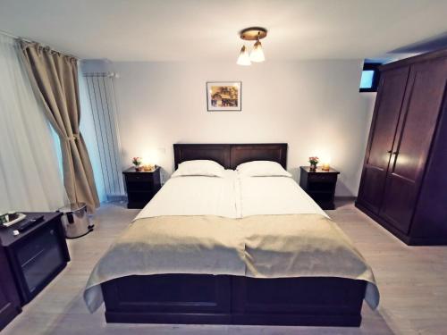 a bedroom with a large bed and two night stands at Complex Parc Pini Moinesti in Moineşti
