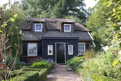 a black house with a thatched roof at Bakhuis Bij Hoestinkhof in Markelo
