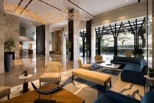 a lobby of a building with couches and chairs at Radisson Blu Mumbai International Airport in Mumbai