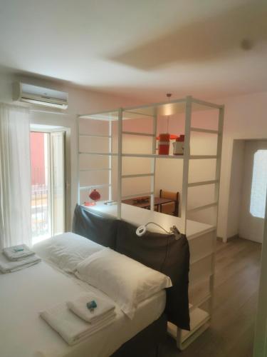 a bedroom with a large bed with a shelving unit at Casa AL CORSO Pozzuoli Centro in Pozzuoli