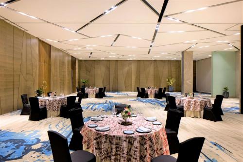 a ballroom with tables and chairs and a large room with tables and chairsktop at Radisson Blu Mumbai International Airport in Mumbai