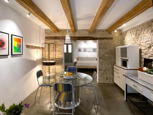 a kitchen and dining room with a glass table and chairs at Castello di Granarola Relais - Adults Friendly - in Gradara