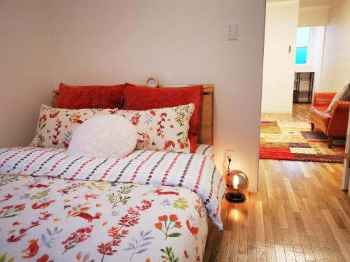 a bedroom with a bed with a red headboard at Opopo home 堺町店 in Otaru