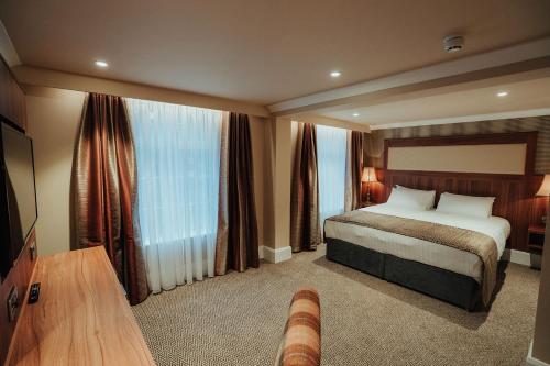 a hotel room with a bed and a large window at Dunadry Hotel And Gardens in Antrim
