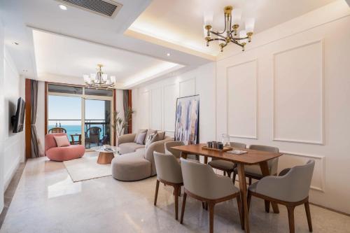 a living room with a dining room table and chairs at Sanya Yikehai View Apartments in Sanya