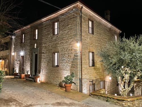 a brick building with plants in front of it at night at Castello di Granarola Relais - Adults Friendly - in Gradara
