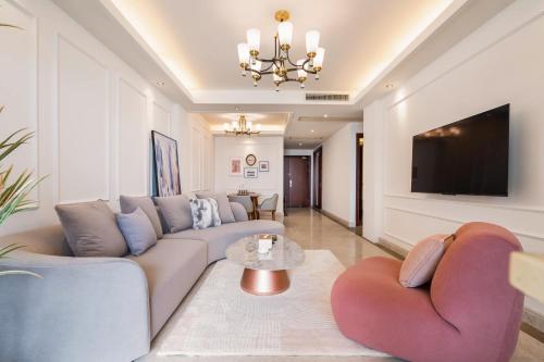 a living room with a couch and a tv at Sanya Yikehai View Apartments in Sanya