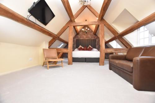 sala de estar con cama y sofá en The Halford Bridge Inn en Shipston on Stour