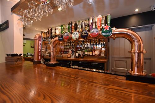 un bar con un montón de botellas en la pared en The Halford Bridge Inn en Shipston on Stour
