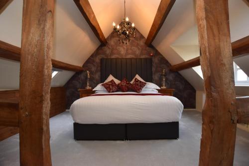 a bedroom with a large bed in the attic at The Halford Bridge Inn in Shipston on Stour