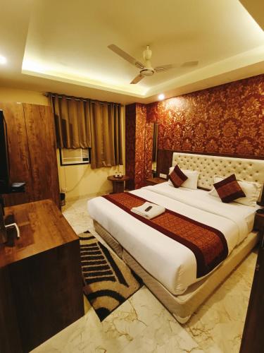 a bedroom with a large bed and a desk at Mayda Inn- A Boutique Hotel in New Delhi