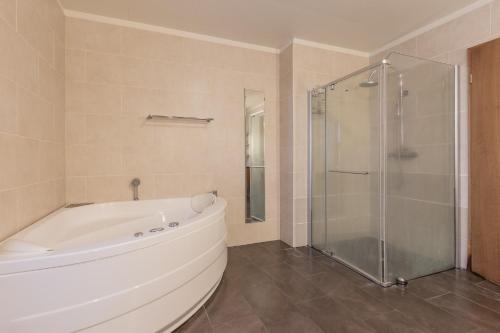 a bathroom with a tub and a glass shower at Margrétarhof in Hella