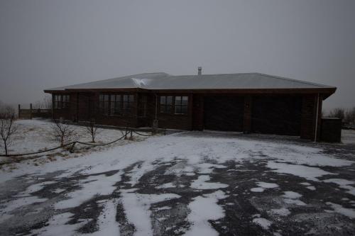 a building with snow on the ground in front of it at Margrétarhof in Hella