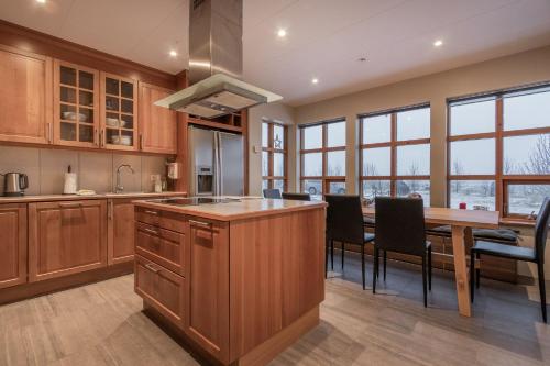 a kitchen with wooden cabinets and a table with chairs at Margrétarhof in Hella
