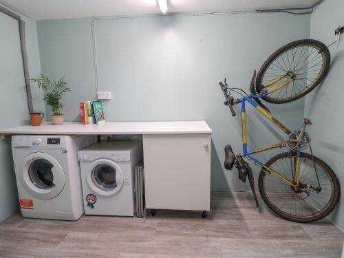 a bike hanging on a wall next to a washing machine at The Corner House in Uttoxeter
