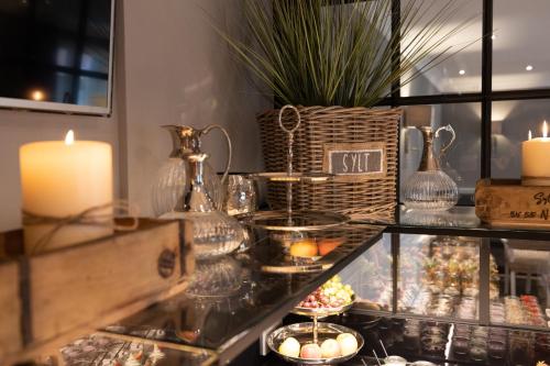 a display case with candles and candlesticks on a table at Das Windhuk in Westerland (Sylt)
