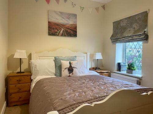 a bedroom with a bed with a cat sitting on it at Bronte Bungalow - In Beautiful Bronte Country! in Oxenhope