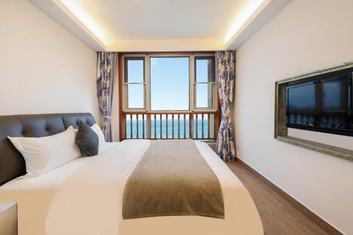 a bedroom with a bed and a window at Sanya Yikehai View Apartments in Sanya