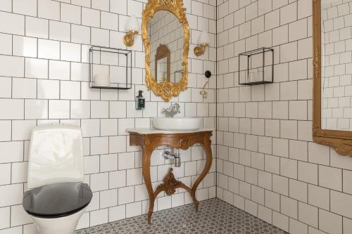 a bathroom with a sink and a toilet and a mirror at Hotell Hamngatan 27 in Falkenberg