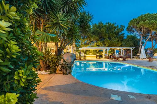 una piscina en un patio con plantas en Albergo Residenziale Menhirs, en Putzu Idu