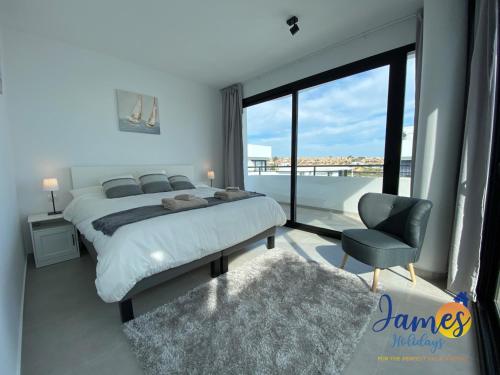 sypialnia z łóżkiem, krzesłem i oknem w obiekcie Luxurious Villa Private Pool La Marina Urb LM3 w mieście San Fulgencio