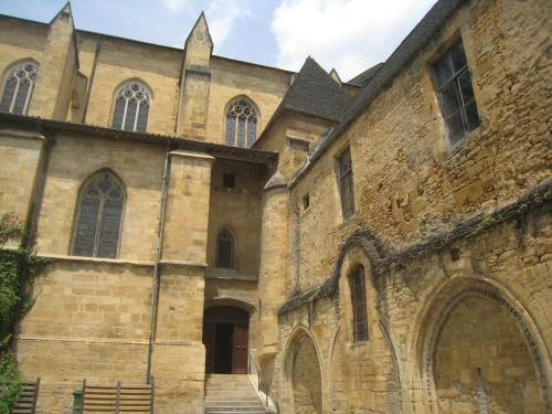 an old brick building with a gate and a tower at Sarlat.Catalina in Sarlat-la-Canéda