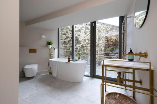 a bathroom with a tub and a toilet and a sink at JOIVY Observatory House & Apartment in Edinburgh