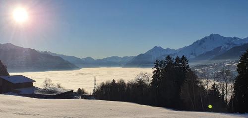 a snow covered field with mountains in the background at Appartement Lens in Lens