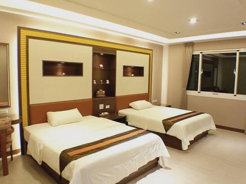 a hotel room with two beds and a mirror at 台東-卑南綠隧-民宿 --- Green Tunnel BnB in Binlang