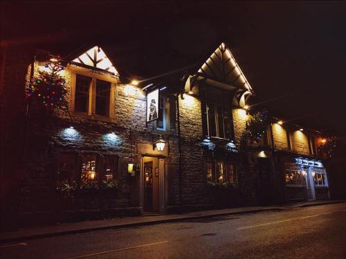 a building with lights on the side of it at night at Peak Hotel Castleton in Castleton