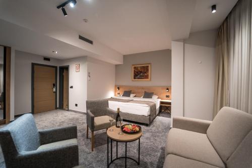 um quarto de hotel com uma cama e duas cadeiras e uma mesa em Mona Plaza Zlatibor em Zlatibor