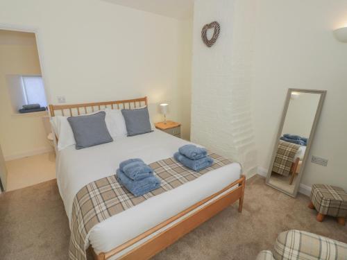 a bedroom with a bed with blue towels on it at Bumble Cottage in Warwick