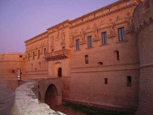 a large brick building with a bridge in front of it at Masseria delle Rose 1760 in Alessano