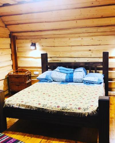 1 dormitorio con 1 cama en una cabaña de madera en У Віти номер3, en Synevyrsʼka Polyana