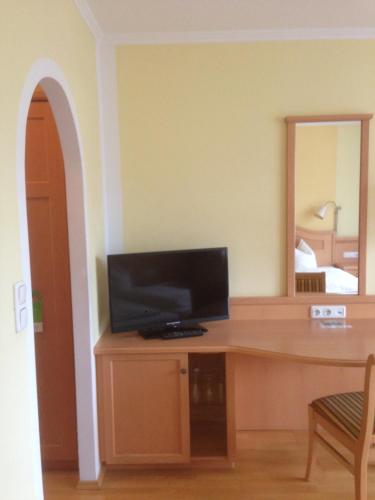 a room with a desk with a television and a mirror at Peterwirt in Bad Mitterndorf