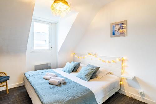 une chambre avec un lit avec deux animaux en peluche dessus dans l'établissement Le Hygge, à Saint-Malo