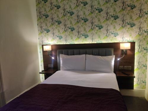 a bedroom with a bed with a flowery wall at Chelsea House Hotel - B&B in London