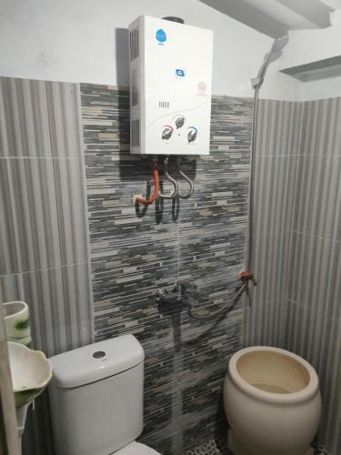 a bathroom with a white toilet and a sink at jala sutra cottages in Giri