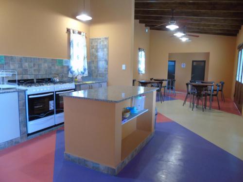 a kitchen with a island in a room with tables at Bella Luna in San Marcos Sierras
