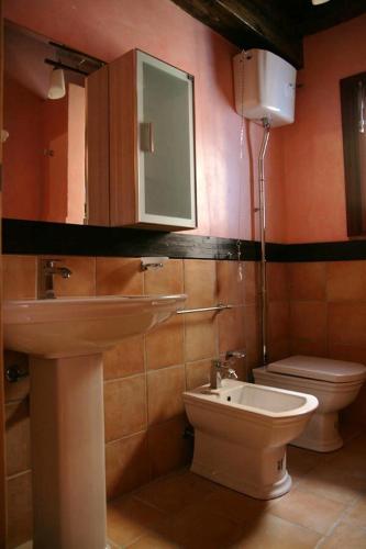 a bathroom with a sink and a toilet and a mirror at Marnabianca Apartment in Realmonte