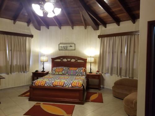 a bedroom with a bed and two lamps and a chair at Apart-Hotel San Ignacio-Boutique 5 Estrellas in San Ignacio de Velasco
