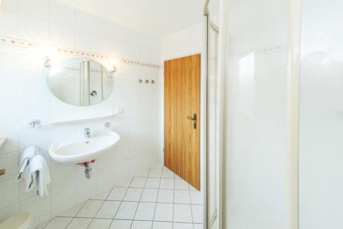 a white bathroom with a sink and a mirror at Ferienwohnung Brack in Reit im Winkl