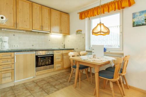a kitchen with a table and chairs and a window at Ferienwohnung Brack in Reit im Winkl